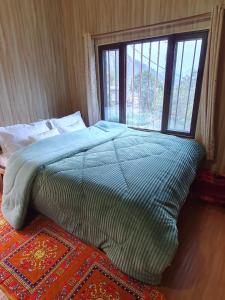 瑞诗凯诗Aum 108 Retreat - Rishikesh Mountains的一间卧室设有一张大床和窗户