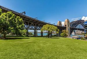 悉尼Opera & Harbour bridge view penthouse (3 rooms)的一座穿越绿草公园的桥梁