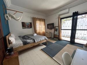 达喀尔Villa Jade的一间卧室设有一张床和一个大窗户