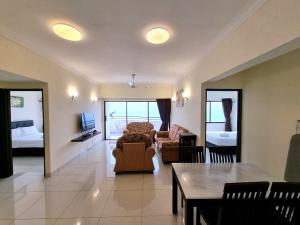 峇都丁宜绿洋海景公寓的客厅配有沙发和桌子