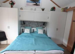 艾格蒙宾能Bungalowpark Mooyeveld的一间卧室配有一张带蓝色床单的大床