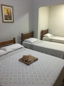 巴雷图斯Hotel Portela I -Barretos的房间里的三张床,上面装有袋子