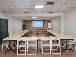 土伦Ibis Budget Toulon Centre的一间会议室,配有桌子和投影屏幕