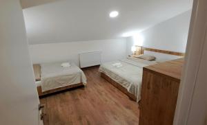 古多里Matt & Sarah’s Cozy Family Duplex的一间卧室设有两张床,铺有木地板