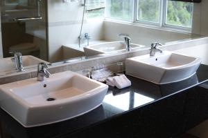 金马仑高原金马仑高原遗物酒店的一间带两个盥洗盆和大镜子的浴室