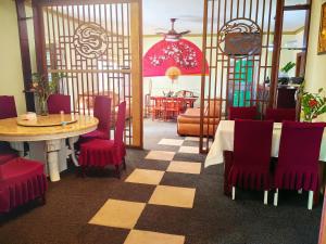 阿克拉hongyuanprimierhotel的一间带桌子和红色椅子的用餐室