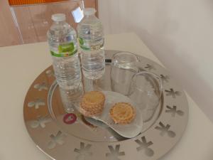 LannilisLes Chambres d'hôtes de Kérasquer的托盘上放有两瓶水和饼干