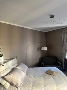 圣雷莫Primafila Premium Guest House的卧室配有白色的床和椅子