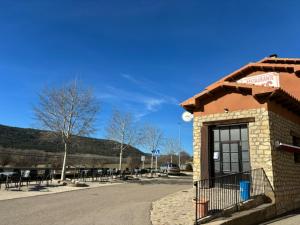 Torres de AlbarracínHotel el Cid的停车场内带桌椅的建筑