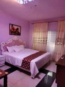阿克拉hongyuanprimierhotel的一间卧室设有一张紫色墙壁的大床