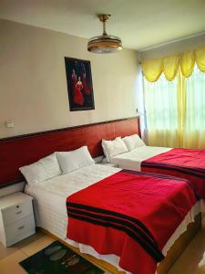 阿克拉hongyuanprimierhotel的一间卧室配有两张红色和白色床单