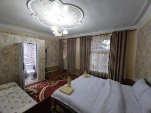 撒马尔罕Fayz Guest House的一间卧室配有一张大床和一个吊灯。