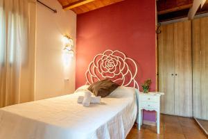 埃斯普霍斯La Pérgola Habitaciones Rústicas的卧室配有一张墙壁上涂有鲜花的床。