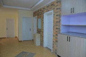 亚的斯亚贝巴Bella Furnished Apartment 2的一个空房间,有砖墙和厨房