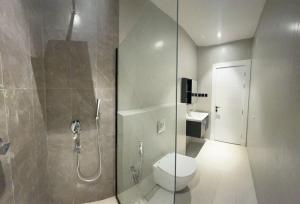 利雅德Al Azmy Al Ared Hotel的一间带卫生间和玻璃淋浴间的浴室