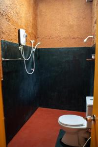 丹不拉加拉日度假酒店的一间带卫生间和墙上软管的浴室