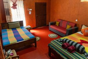 丹不拉加拉日度假酒店的一间带两张床和一张沙发的客厅