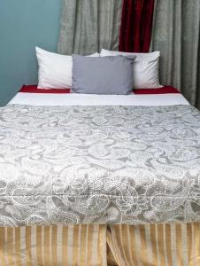 卡斯特里Bougainvillea Apartments 2的一张带白色床单和枕头的床