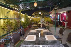 巴特那Hotel Virasat Retreat的一间设有桌椅和植物的餐厅