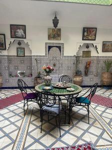 马拉喀什HOTEL EL AMAL的客房设有桌椅和壁炉。