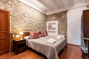 CapmanyHostal Can Xicu的一间卧室设有一张床和石墙