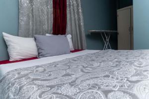 卡斯特里Bougainvillea Apartments 2的一间卧室配有带白色床单和枕头的床。