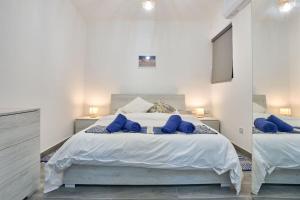 圣保罗湾城Two Bedroom Apartment in Xemxija, St. Paul's Bay的一间卧室配有一张大床和蓝色枕头