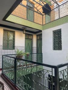 马拉喀什HOTEL EL AMAL的带阳台的房屋,设有绿门