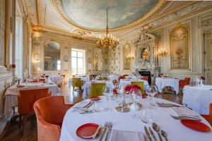 莫索特Château & Spa de la Cueillette的餐厅配有白色的桌椅和吊灯