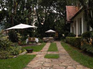 彼得罗波利斯Estúdios no Resort Granja Brasil em Itaipava的庭院配有遮阳伞和桌椅。