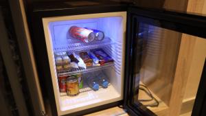 阿尤恩MH HOTEL LA CASA的配有食品和饮料的开放式冰箱