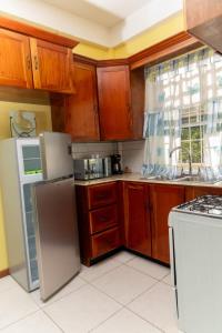 卡斯特里Bougainvillea Apartments的厨房配有木制橱柜和白色家电