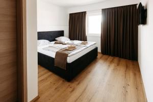 普图伊穆拉特酒店的一间卧室配有一张床,铺有木地板