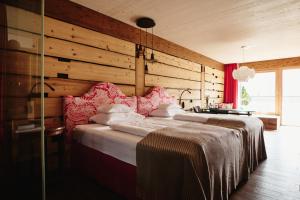 齐勒河谷采尔Small Luxury Hotel of the World - DasPosthotel的一间卧室设有两张床和木墙