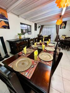 哈博罗内Keeme-Nao Self Catering Apartments的用餐室配有长木桌子和椅子