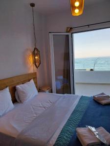 帕拉塔蒙Galazio Seaside Luxury Rooms & Coffee Shop的一间卧室设有一张床,享有海景