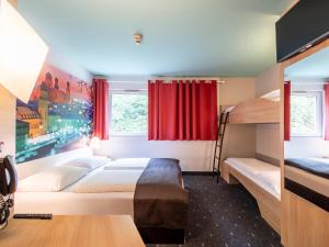 帕绍帕绍住宿加早餐酒店的一间卧室设有两张双层床和红色窗帘