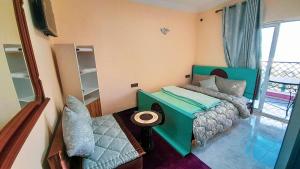 SefrouSIDI ALI BOUSSERGHINE的一间带绿色床的卧室和一个阳台