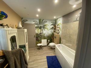 图兰的圣莫尔La Patriaie. chez Jacky et Maryse.的一间带浴缸的浴室和墙上的棕榈树