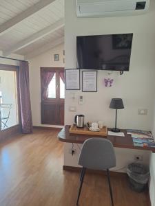 斯特雷萨Al San Michele的客房设有一张桌子、一把椅子和一台电视。