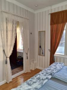 HammarlandParadiset的一间卧室配有床和两个带窗帘的窗户
