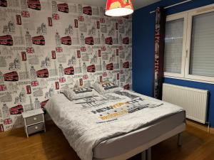 博纳勒斯麦斯Grande Maison Moderne的一间卧室配有一张带挂有拼音的墙壁的床