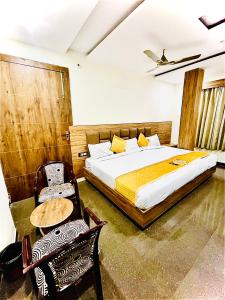 马图拉Hotel Superhouse by Wisdom Madhav的卧室配有一张床和一张桌子及椅子