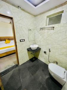 马图拉Hotel Superhouse by Wisdom Madhav的一间带水槽和卫生间的浴室以及一张床