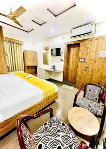 马图拉Hotel Superhouse by Wisdom Madhav的酒店客房带一张床、一张桌子和椅子