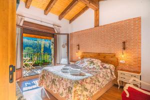 赫尔特Casa Rural La Chopera del Jerte的一间卧室设有一张床和砖墙