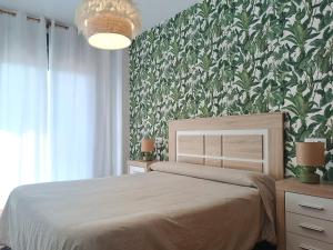 奥利瓦Lujoso apartamento en Oliva的一间卧室设有一张床和绿色的墙壁
