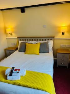 布拉克利布莱克利皇冠大酒店的一间卧室配有一张带黄色长凳的大床