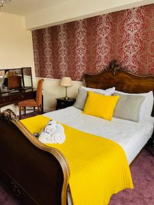 布拉克利布莱克利皇冠大酒店的一间卧室配有一张带黄色毯子的大床