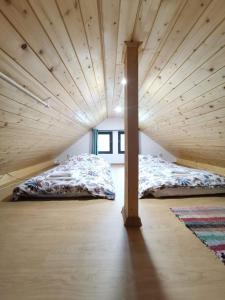 Stefana's Tiny House Nature Retreat的配有木天花板的客房内的两张床